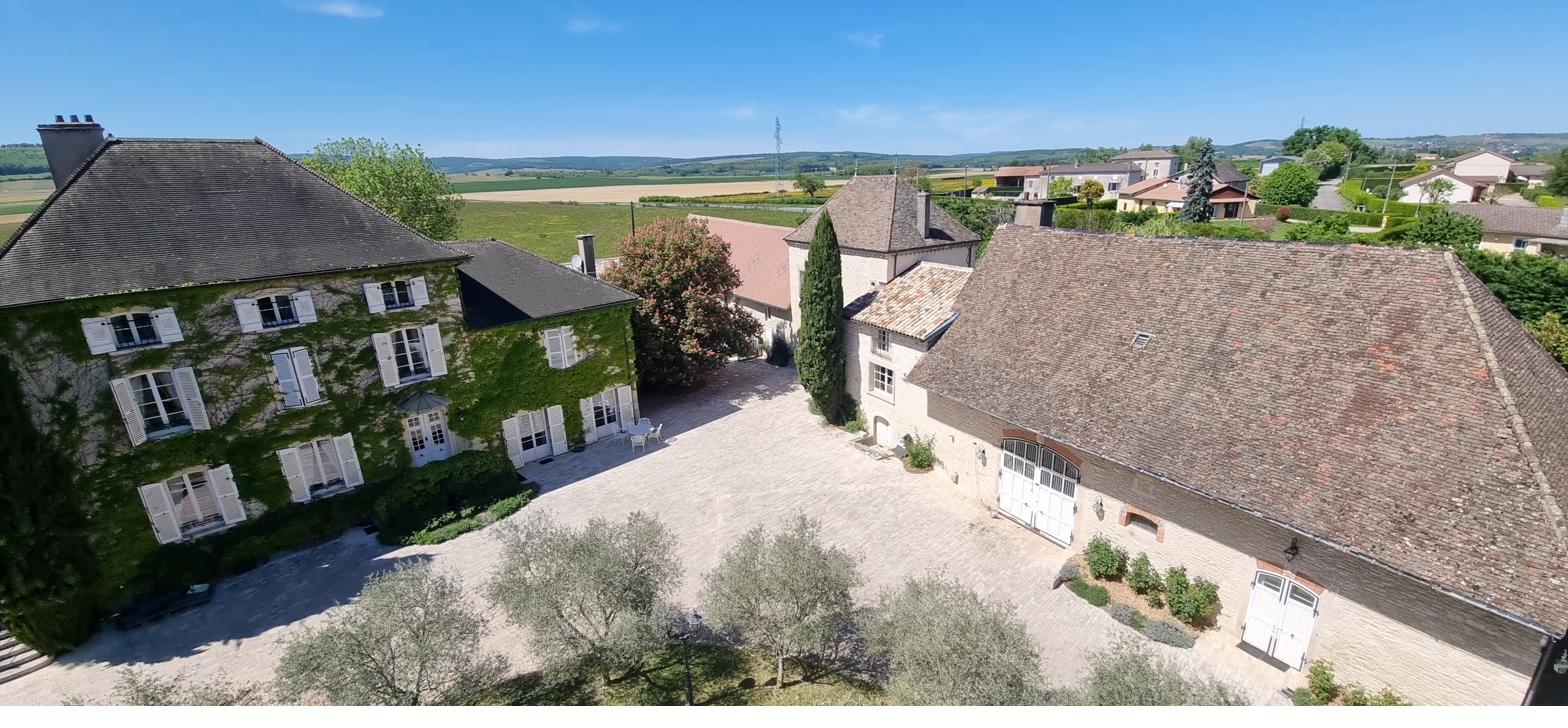 The estate from above — the main house, the tower, the barn and the Mâconnais hills beyond.