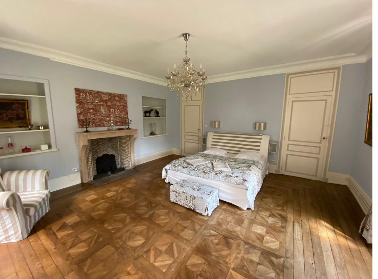 Chambre Bleue — pale blue walls, stone fireplace and crystal chandelier.