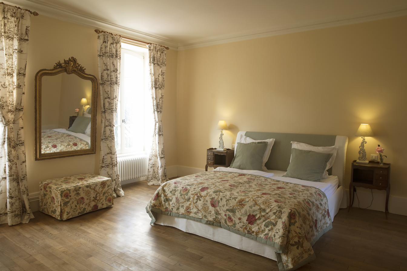 Chambre Jaune, warm and golden with a gilt mirror.