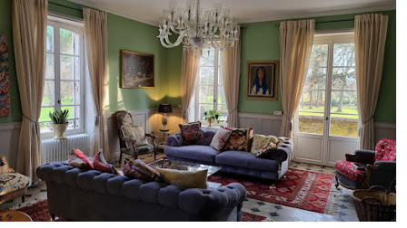 A green-walled sitting room in the main house, with a chandelier and views onto the garden.