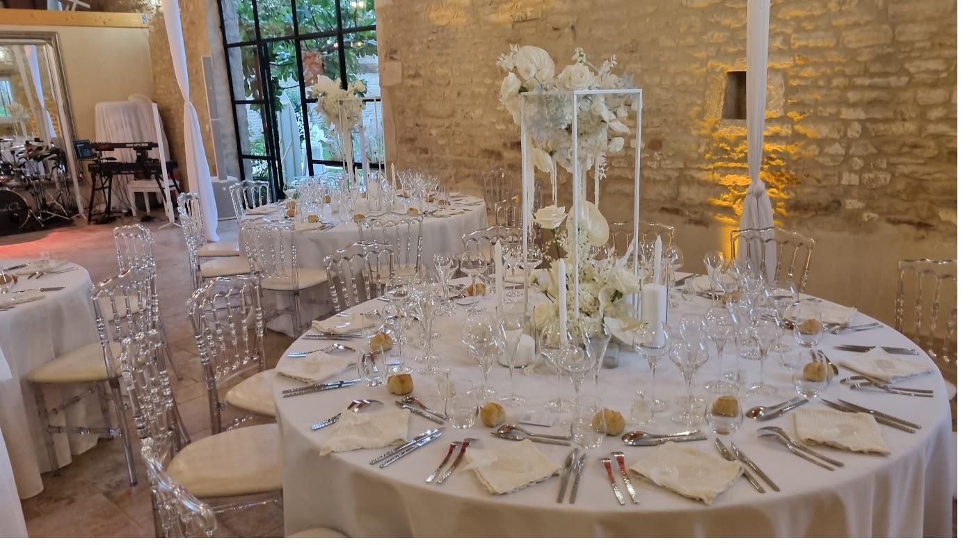 Round tables laid for a wedding dinner under the beams.