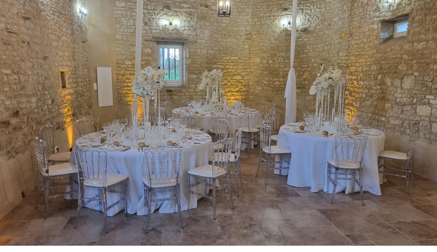 Tables set for an evening wedding reception, candlelight against the old stone walls.