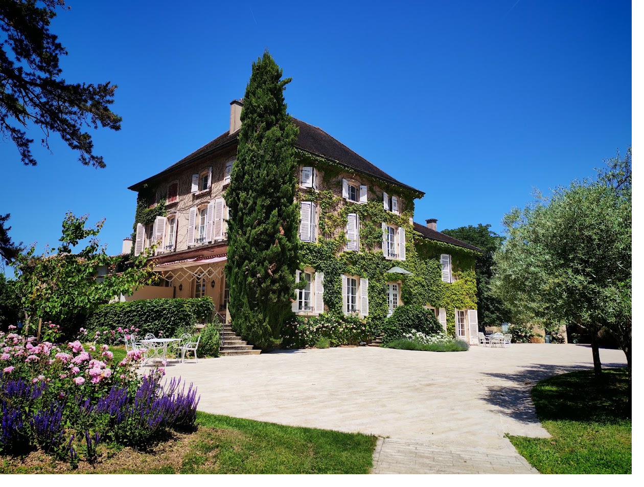 The main house at Château de Mirande, its facade covered in climbing greenery, seen from the terrace.